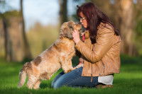 Une femme fait un câlin à son chien dans un jardin