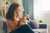 Une jeune femme et son Shiba Inu assis sur un canapé