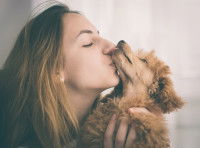 Une femme fait un bisou à son Caniche