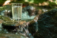 Un verre d'eau pure à côté d'une source