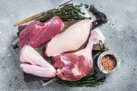 Des cuisses de canard cru sur un plateau