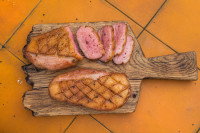 Des morceaux de magret de canard sur une planche