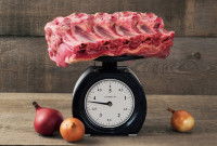 Un morceau de viande de boeuf crue posé sur une balance