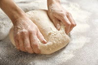 Une femme pétrit de la pâte à pain