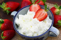Un fromage blanc dans une tasse avec des fraises