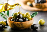Des olives vertes et noires dans un bol, et un flacon d'huile d'olive