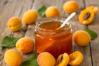 De la confiture d'abricots et des abricots posés sur une table