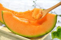 Des tranches de melon et une cuillère en bois