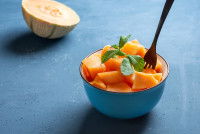 Des cubes de melon frais dans un bol avec une fourchette