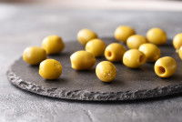 Quelques olives vertes posées sur une assiette