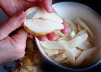 Une femme coupe une poire en morceaux
