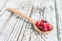 Une cuillère en bois contenant des baies de cranberry