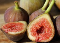 Des figues entières et coupées sur une table en bois