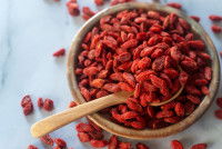 Des baies de goji séchées dans un bol en bois