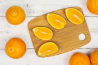 Des oranges entières et des quartiers sur une planche de bois