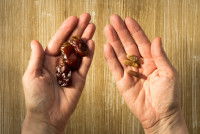 Un homme tient des noyaux de datte dans les mains