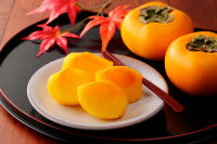 Des kakis coupés en tranche dans une assiette