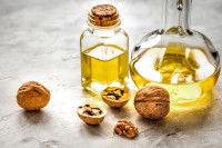 Des noix et des flacons d'huile de noix posés sur une table