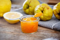 Un petit pot contenant de la confiture de coing avec une cuillère