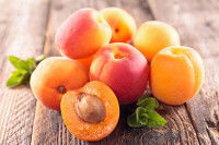 Une pile d'abricots posés sur une table en bois