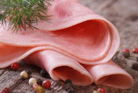 Des tranches de jambon cuit sur une table en bois