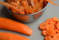 Des carottes entières et en rondelles sur une table grise