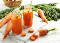Des carottes entières et du jus de carotte dans des verres