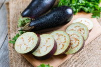 Une aubergine en tranches sur une planche en bois