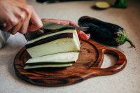 Une femme découpe une aubergine avec un couteau