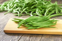 Des haricots verts sur une planche en bois