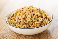 Une assiette de quinoa cuit sur une table en bois