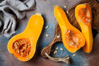 Des moitiés de butternut sur une planche de cuisine