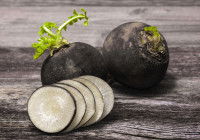 Des radis noirs posés sur une table de bois