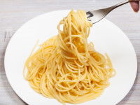 Une assiette contenant des spaghettis avec une fourchette