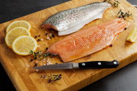 Un filet de poisson avec la peau sur une planche de bois