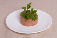 Un morceau de pâtée pour chien déposé dans une assiette