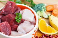 Bol de viande crue à côté de fruits et légumes