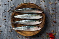 Des sardines dans une assiette sur un fond en bois