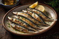 Des sardines grillées dans une assiette avec du citron