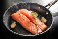 Des pavés de saumon en train de cuire dans une poêle