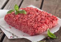 Un pavé de steak haché sur du papier sur une table en bois