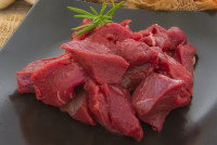 De la viande crue de gibier dans une assiette noire