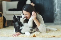 Une jeune femme et son chiot Husky se font des bisous