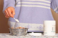 Un homme verse un complément alimentaire sur la gamelle de son chien