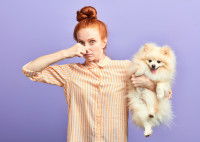 Une femme se pince le nez parce que son spitz sent mauvais