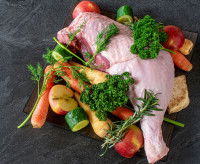 Une cuisse de poulet crue avec des légumes