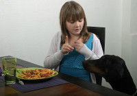 Une femme gronde son chien qui réclame de la nourriture