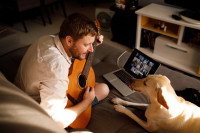 Un homme joue de la guitare pour son chien