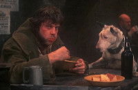 Une scène du film « Oliver Twist » dans laquelle le chien Bull’s Eyes est assis à table à côté de son maître qui mange