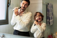 Un homme et son fils se rasant dans une salle de bain
